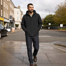 Man wearing black hooded waterproof jacket with jeans, walking outdoors on street | Chaps London