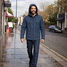 Man wearing navy hooded rain jacket, walking on city sidewalk | Chaps London