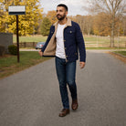 Man wearing navy sherpa trucker jacket with jeans, walking outdoors | Chaps London