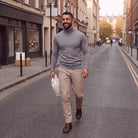 Man wearing grey knit turtleneck sweater with beige trousers on street | Chaps London