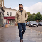 Man wearing beige zip-up rain jacket with dark jeans, walking outdoors | Chaps London