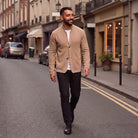 Man wearing tan textured knit cardigan with white tee, walking outdoors | Chaps London
