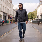 Man wearing dark gray hooded windbreaker, jeans, walking on city street | Chaps London