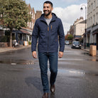 Man wearing navy hooded windbreaker jacket with jeans, walking on street | Chaps London