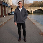 Man wearing grey zip hoodie with black jeans near river | Chaps London