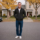 Man wearing black zip jacket with jeans, standing outdoors on street | Chaps London