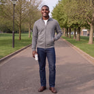 Man wearing gray zip-up jacket with jeans, walking on park pathway | Chaps London