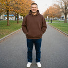 Man wearing brown pullover hoodie outdoors on paved path | Chaps London