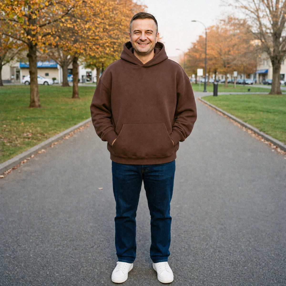 Man wearing brown pullover hoodie outdoors on paved path | Chaps London