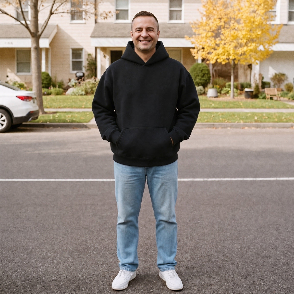 Man wearing black oversized plain hoodie standing outdoors on residential street | Chaps London