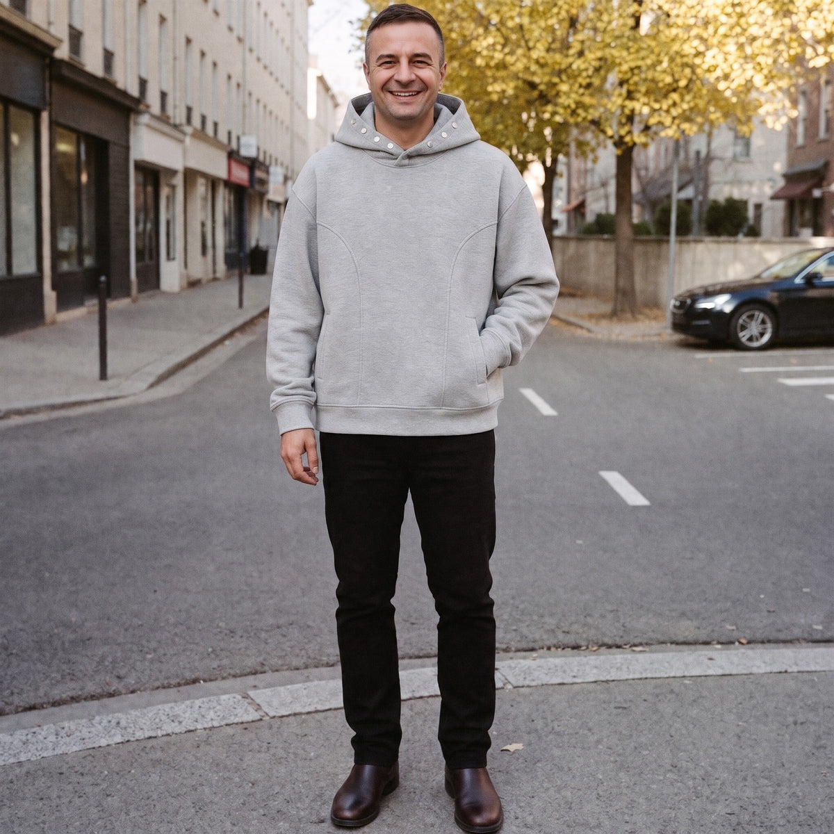 Man wearing gray snap neck hoodie with black pants on street | Chaps London
