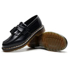 Men's black tassel loafers showing the treaded sole