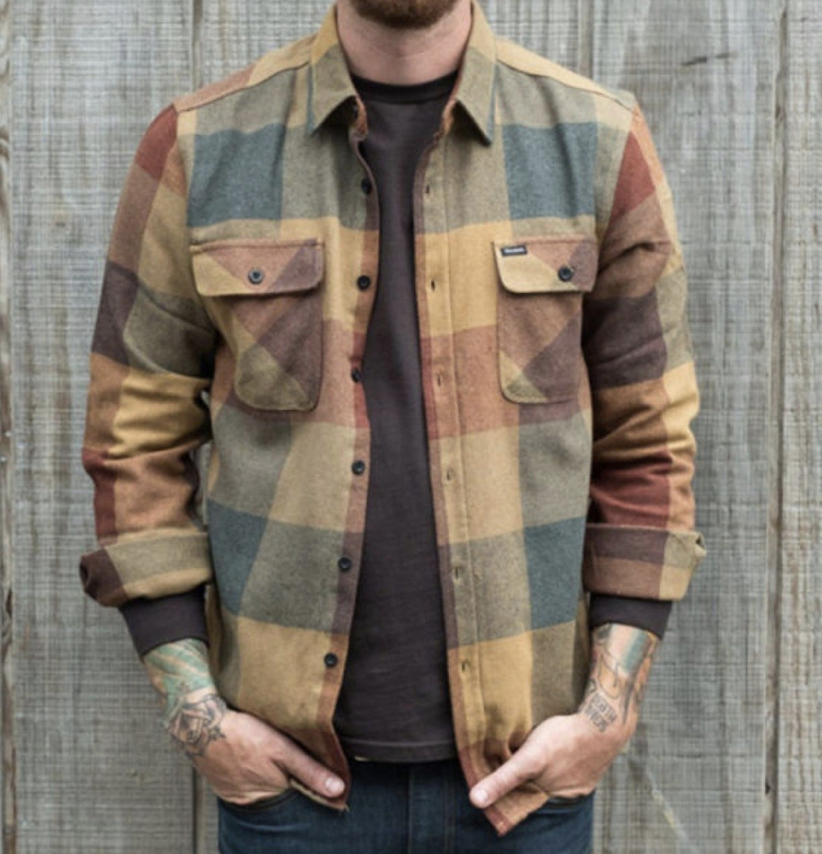 Man wearing a brown, mustard and grey checked lined shirt open over a dark T-shirt | Chaps London
