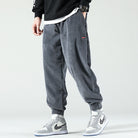 Grey corduroy trousers with a drawstring waist and cuffed ankles