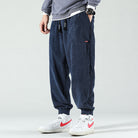 Navy corduroy trousers with a drawstring waist and cuffed ankles