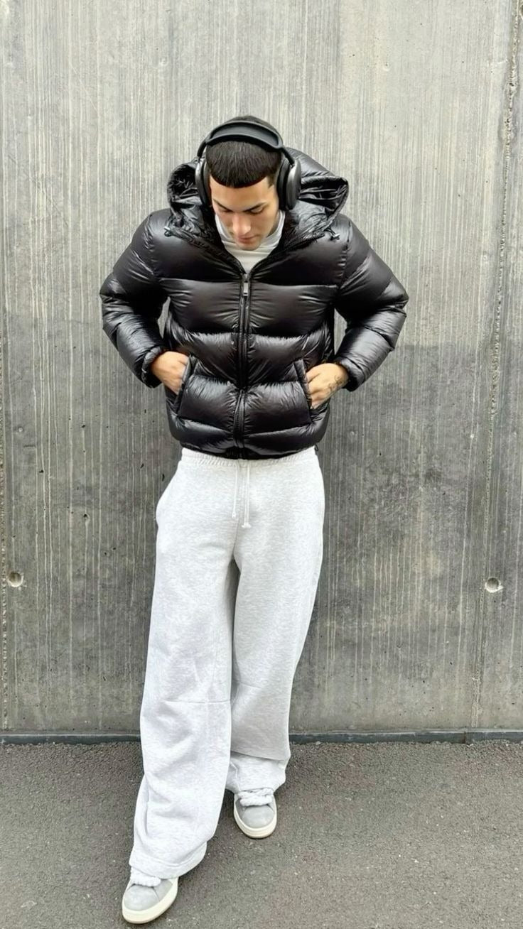 Man in a black high-shine hooded puffer jacket with light wide-leg joggers