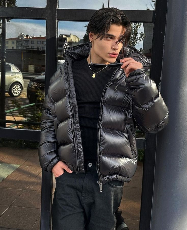 Black shiny puffer jacket worn open over a black top