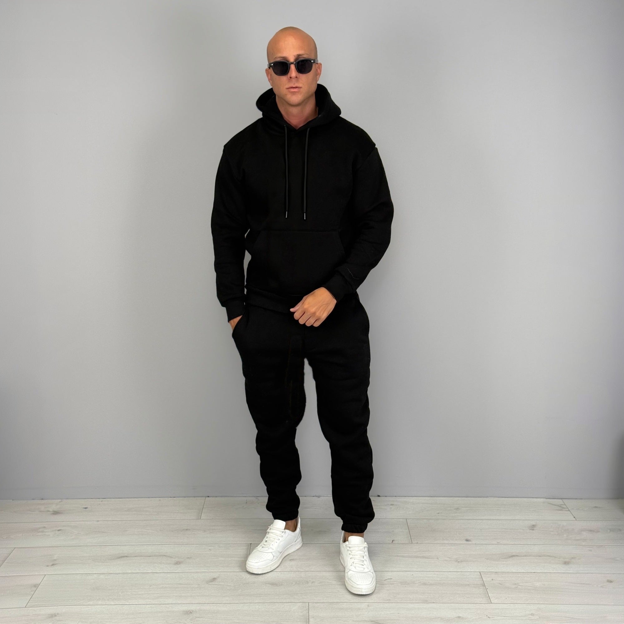 Man wearing black hoodie tracksuit with cuffed joggers and white sneakers | Chaps London