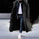 Man wearing black faux fur lined long coat, denim jacket, and jeans outdoors | Chaps London