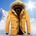 Yellow padded parka with faux fur hood, worn by person, snowy mountains background | Chaps London
