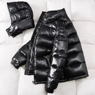 Black glossy puffer jacket with detachable hood, laid flat on fabric | Chaps London