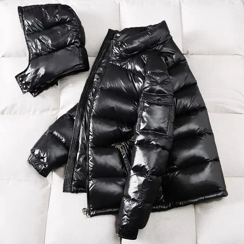Black glossy puffer jacket with detachable hood, laid flat on fabric | Chaps London