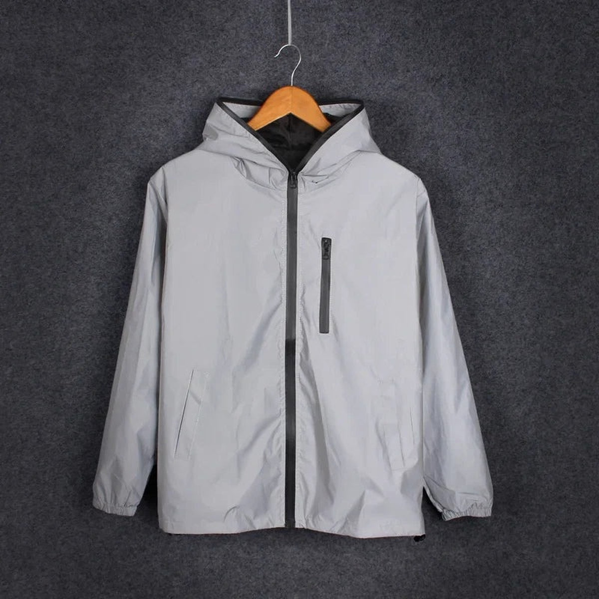 Men's reflective rain jacket in silver grey on a hanger, front view