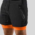 Black and orange 2-in-1 running shorts with a zip pocket