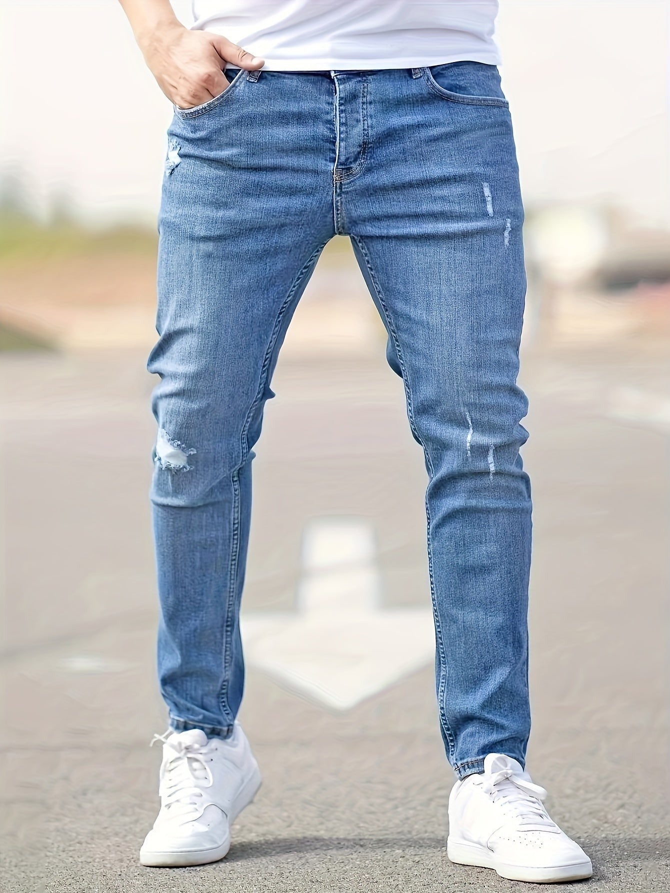 Man wearing blue ripped skinny jeans with white sneakers, front view | Chaps London