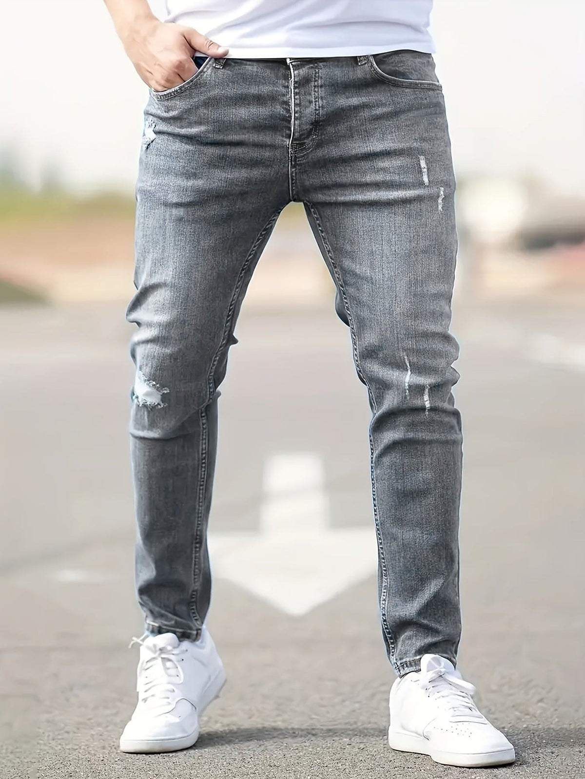 Man wearing gray ripped skinny jeans with white sneakers outdoors | Chaps London