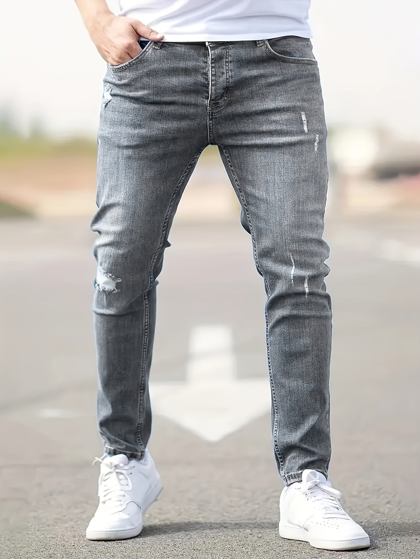 Man wearing gray ripped skinny jeans and white sneakers outdoors | Chaps London