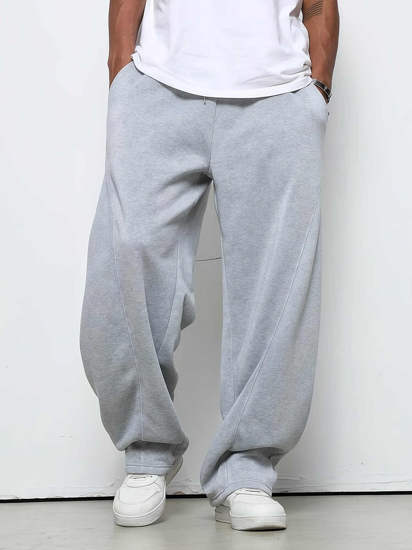 Man wearing baggy grey fleece joggers with drawstring, white t-shirt, sneakers | Chaps London
