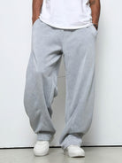 Man wearing baggy grey fleece joggers with drawstring, white t-shirt, sneakers | Chaps London