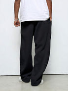 Man wearing black straight-leg baggy joggers, white sneakers, rear view | Chaps London