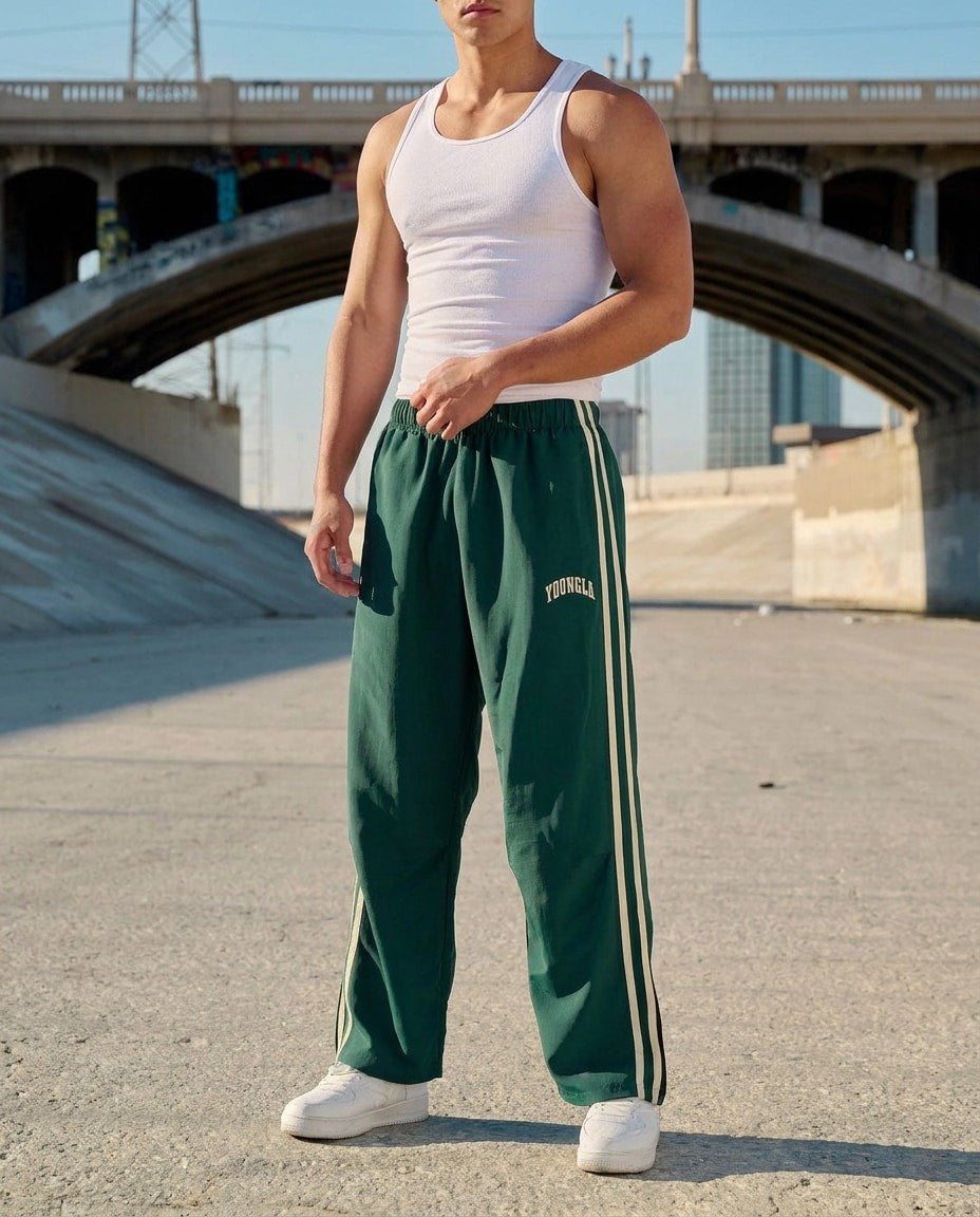 Men's green side-stripe tracksuit bottoms worn outdoors
