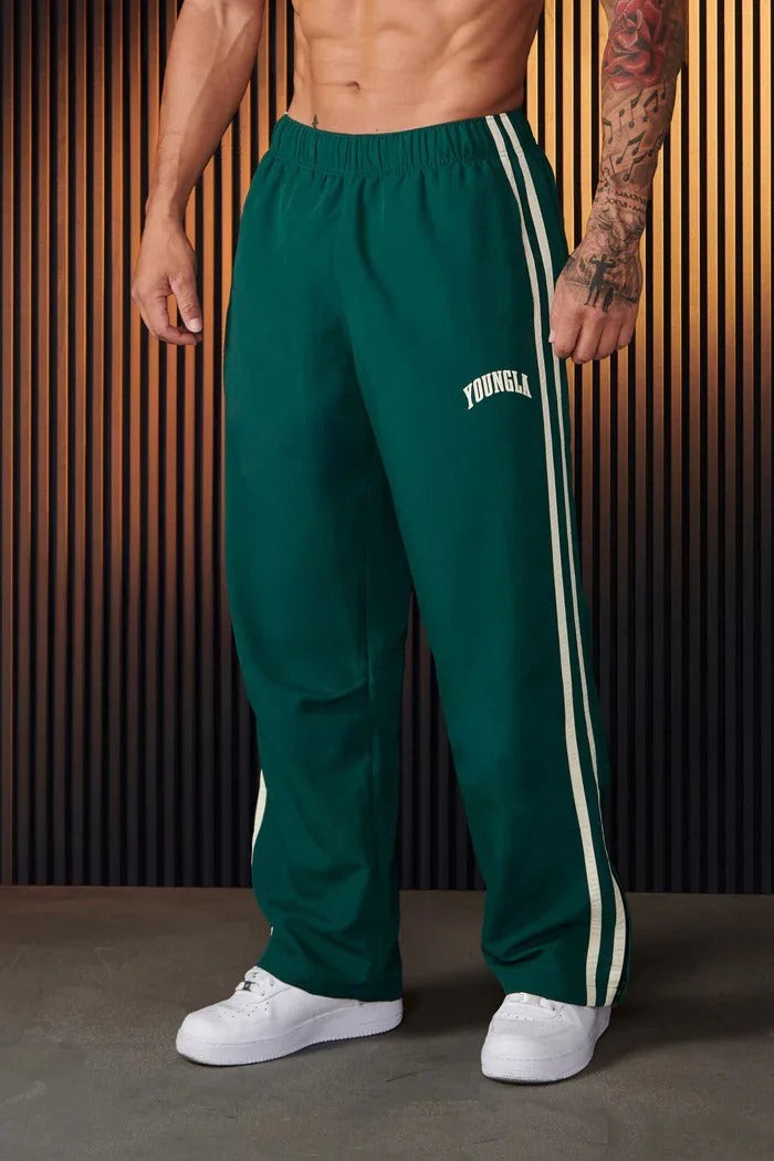 Green tracksuit bottoms with white side stripes, worn by man, front view | Chaps London
