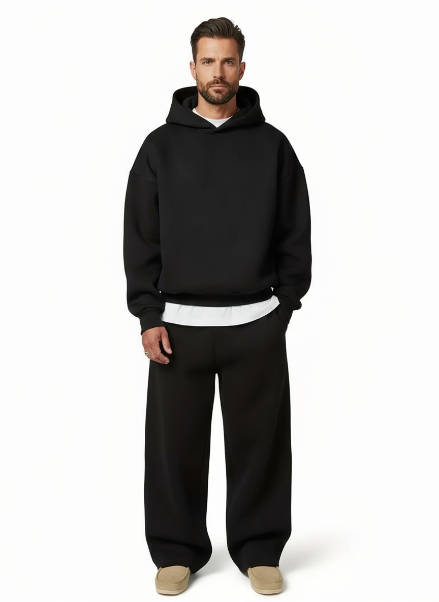 Man wearing black oversized hoodie and straight-leg joggers, tan shoes visible | Chaps London