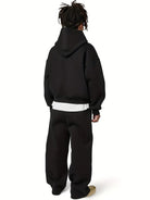 Man wearing black oversized hoodie and matching joggers, rear view | Chaps London
