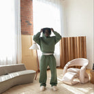 Men's sage green tracksuit set worn in a living room