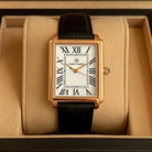 Men's rectangular watch with a gold-tone case and a black leather strap