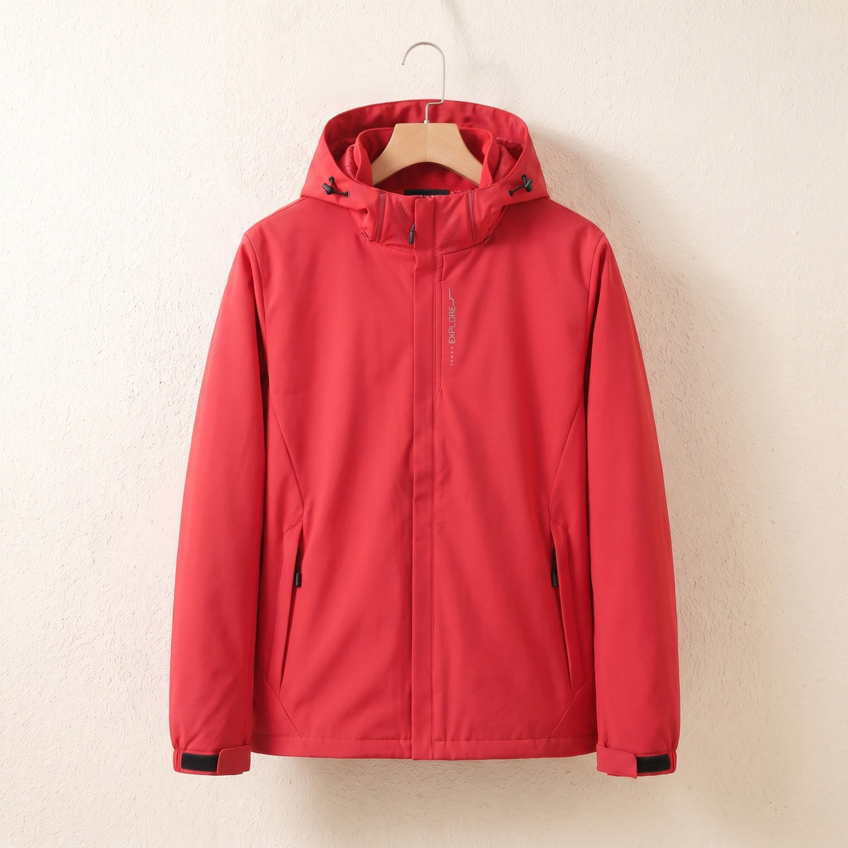 Red waterproof jacket with hood on a hanger