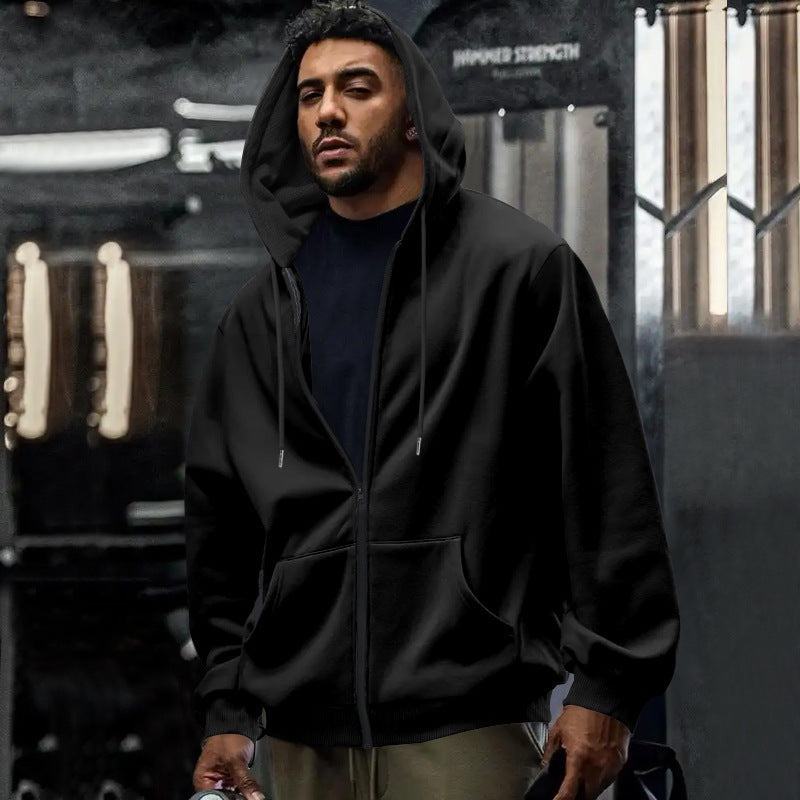 Men's oversized zip-up hoodie in black, worn, front view