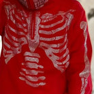 Red hoodie with rhinestone skeleton design, worn by a person, close-up view | Chaps London