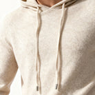 Close-up of oatmeal knit hoodie drawstring with metal tipped cords, worn by person | Chaps London