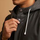 Black snap-front raincoat hood detail worn by person, close-up neckline | Chaps London
