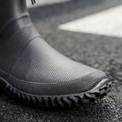 Black textured ankle boot with ridged sole, worn on foot outdoors | Chaps London