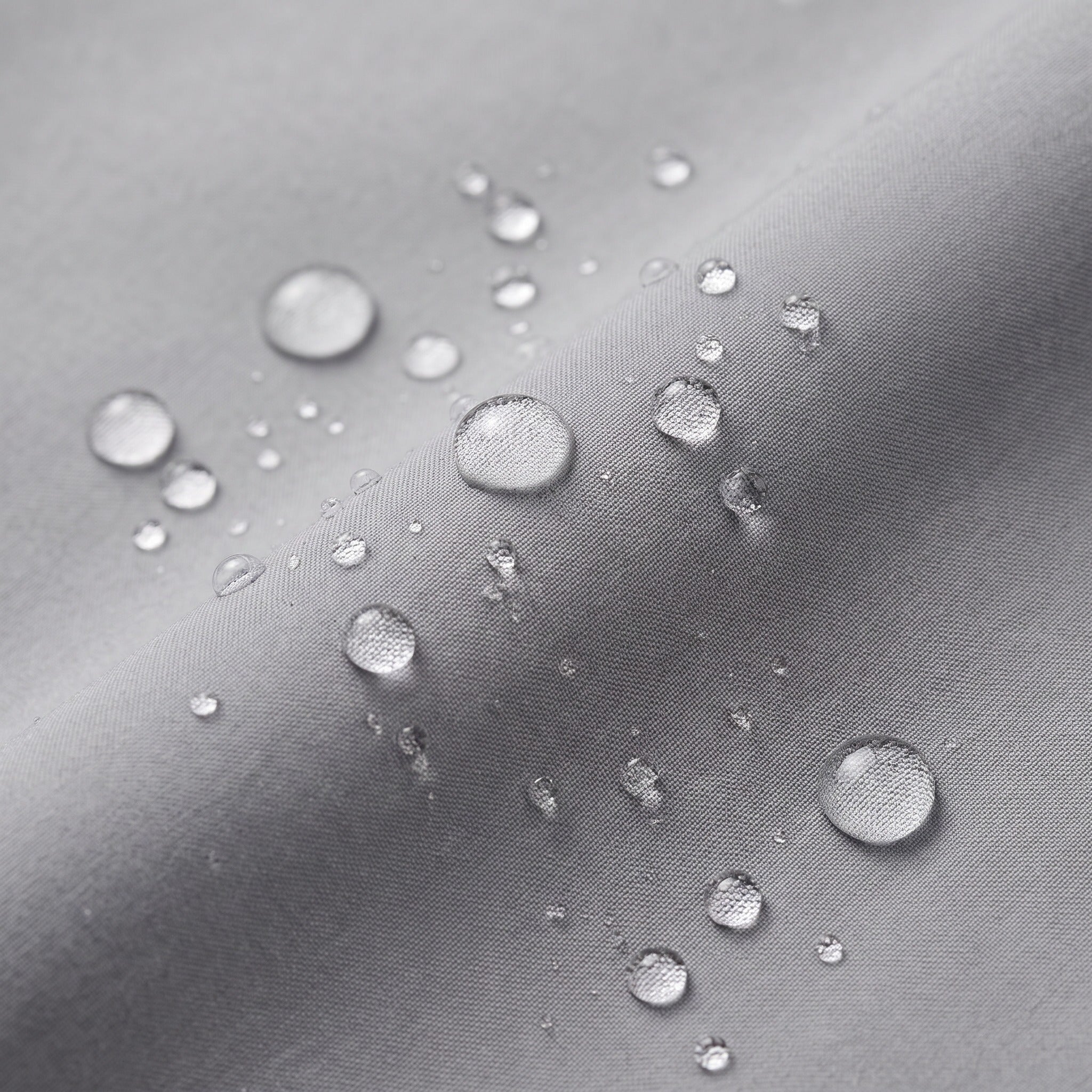 Water droplets beading on gray water-repellent fabric, close-up texture detail | Chaps London