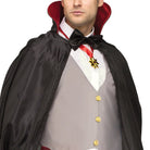 Man wearing black vampire cape with red collar and medallion | Chaps London