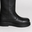 Black leather mid-calf boot, close-up view, worn on person's leg | Chaps London