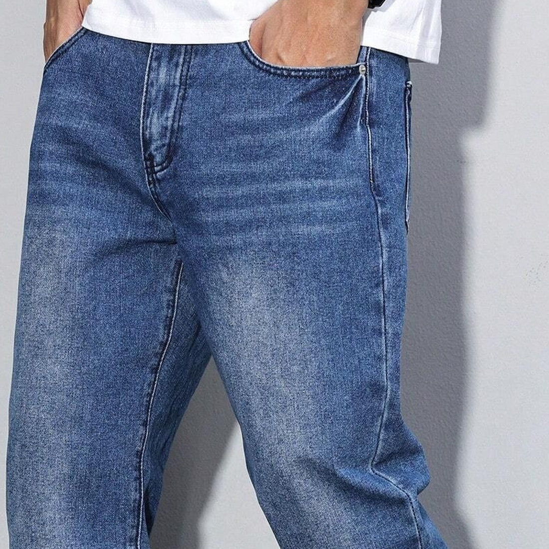 Worn blue denim wide-leg jeans with washed look, model wearing white shirt | Chaps London